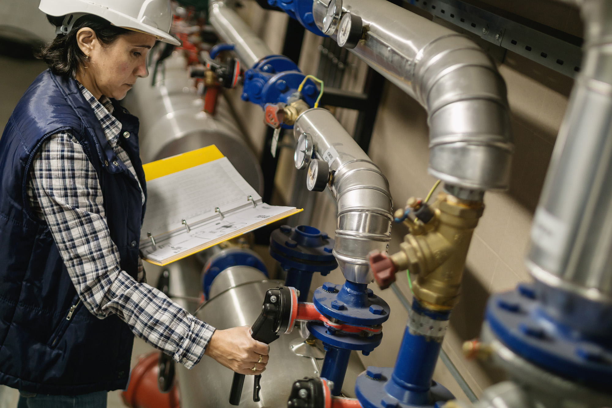 A person reviews a water system and takes notes