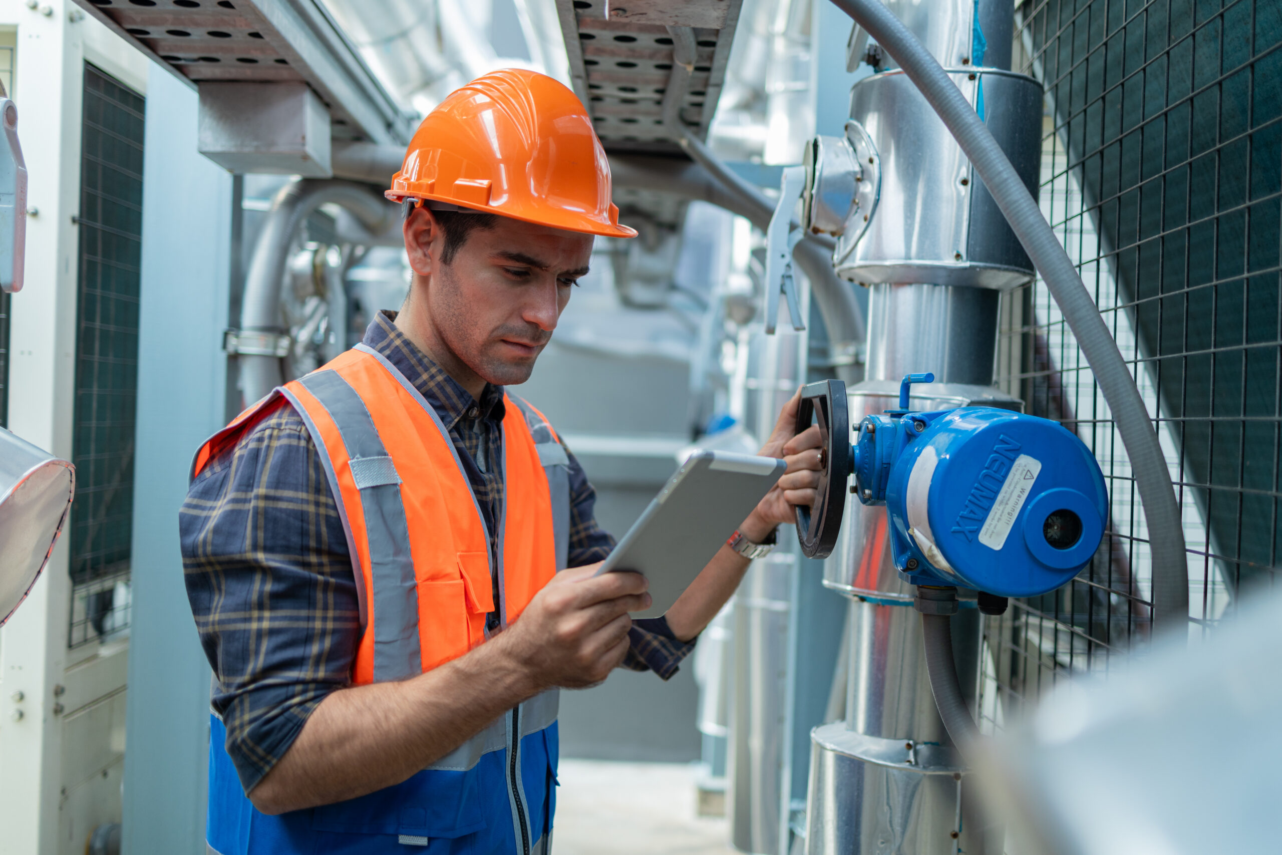 Technician in hard hat checking a valve.