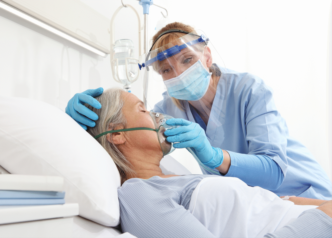 Nurse with an elderly patient applying oxygen mask in a hospital